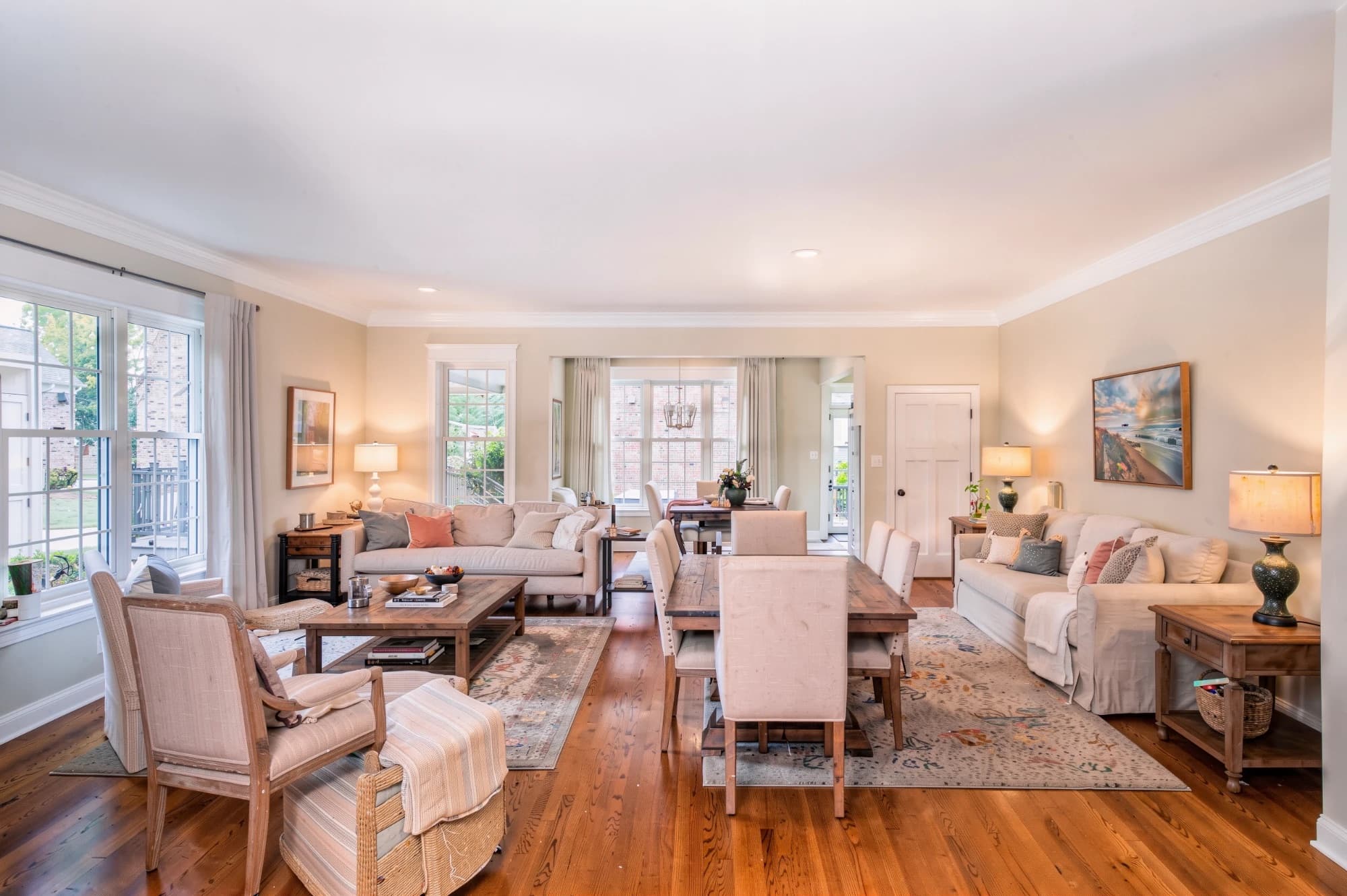 Open living and dining room with freshly painted warm cream walls and crisp white crown molding