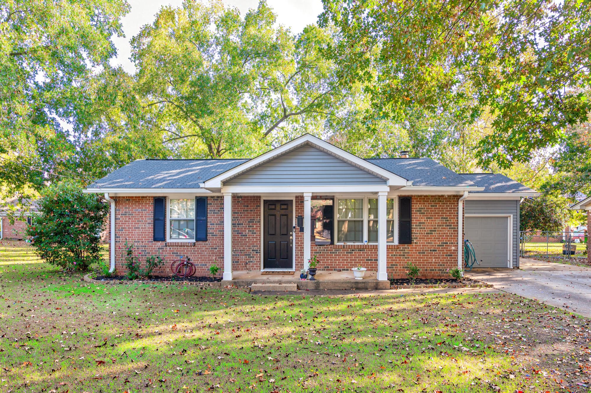 Brick ranch house with freshly painted white trim and porch columns