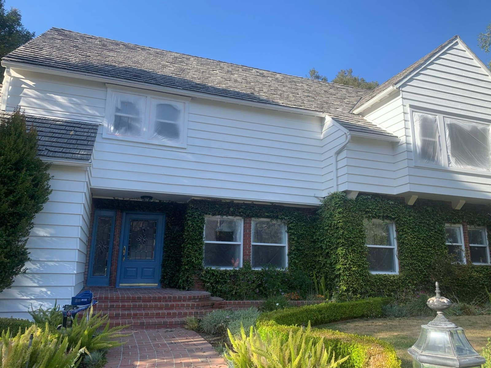 Home with freshly painted white siding and trim and a blue front door